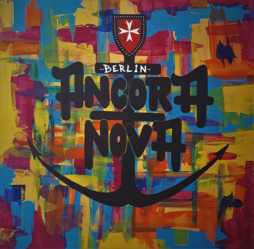Zu sehen ist das Logo des Ancora Nova auf Leinwand gemalt. Es besteht aus vielen bunten Farbklecksen und einem Anker-Symbol